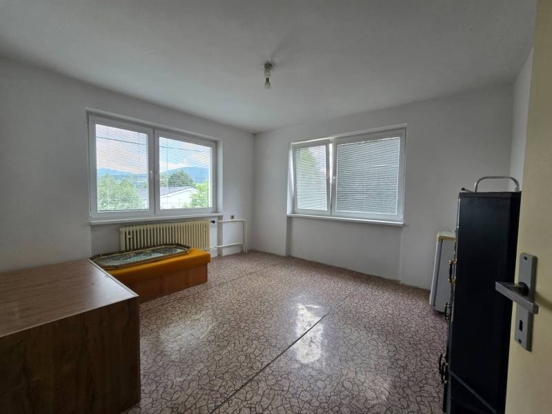 A simple room in a family house with a view through large windows.