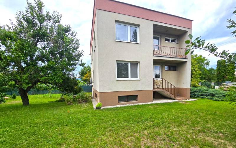 A family house in Nové Mesto nad Váhom with a garden and trees on a grassy area.