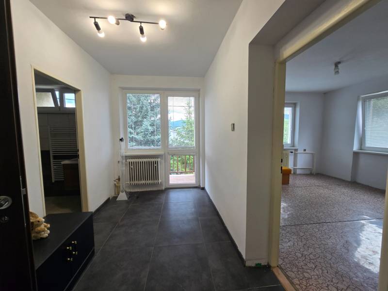 A corridor with tiled flooring leads to the rooms in a family house.