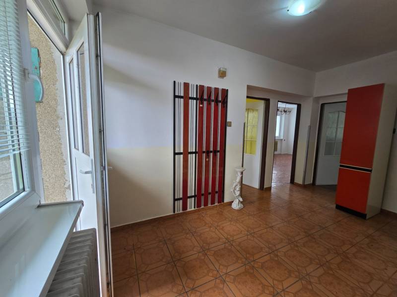 Interior of a family house with an openable window, doors, hangers, and tiles.