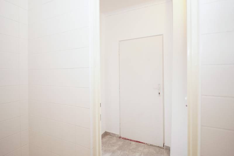 White doors in an office with tiled floors and white walls.