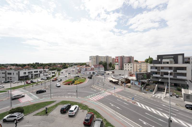 Roundabout with surroundings on Hlavná Street in Dunajská Streda, movement of cars, buildings, sky.