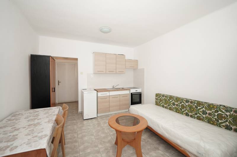 Interior of an office with a kitchenette, table, and sofa.