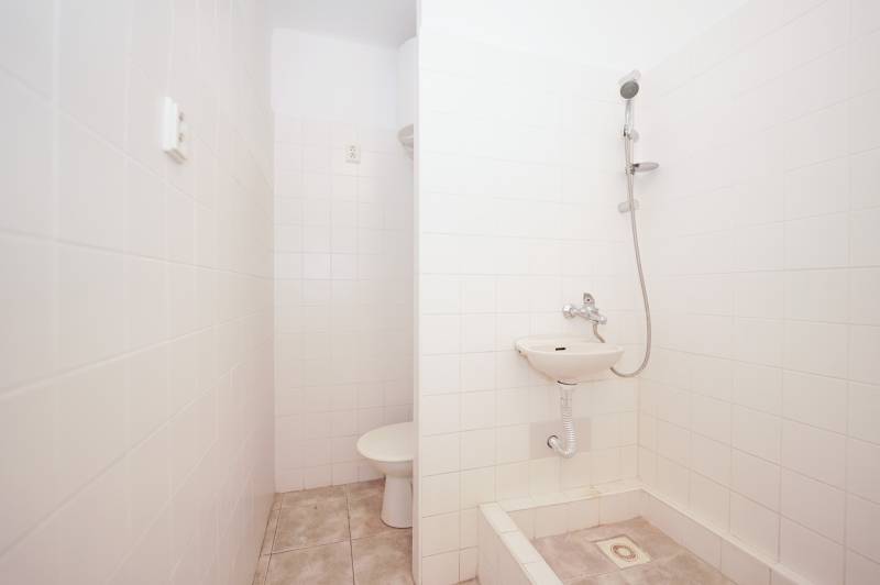 Bathroom with tiles, shower, and sink in the office.