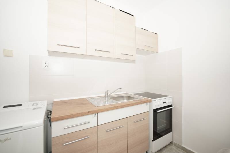 Kitchen corner with sink, washing machine, and hob in the office.