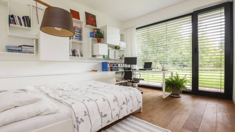 Bedroom with a work corner, wooden floor, garden view, library, family house.