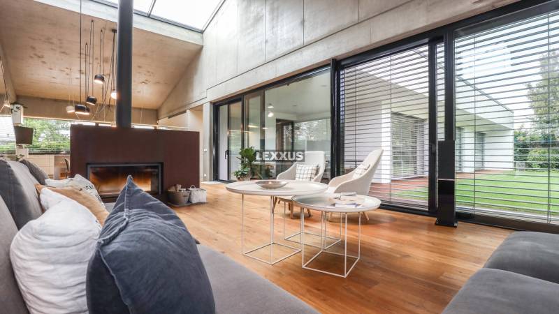 Living room with a fireplace in a family house, large windows overlooking the garden.