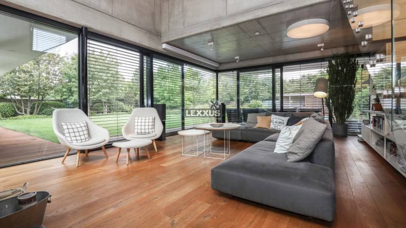 Family house with a glass wall, comfortable furniture, wooden floor, garden view.