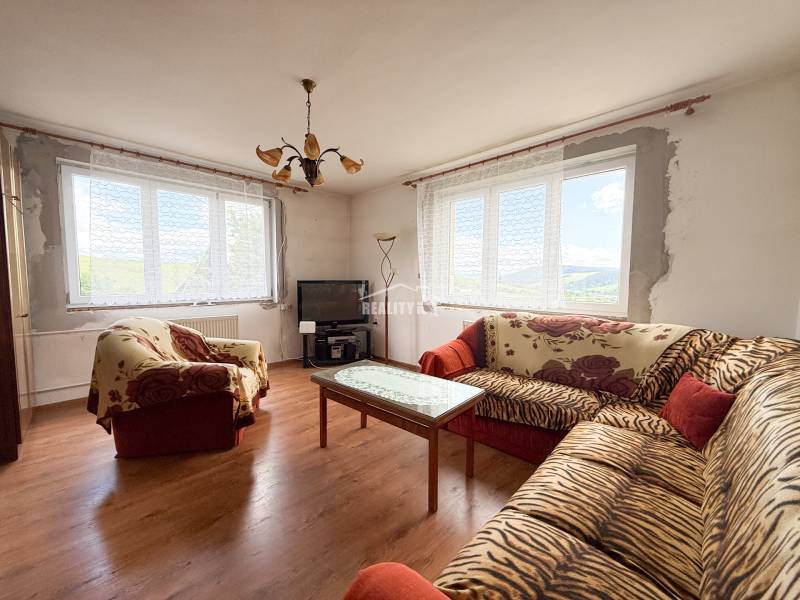 Living room of a family house with sofas, a television, and a table, bright atmosphere.
