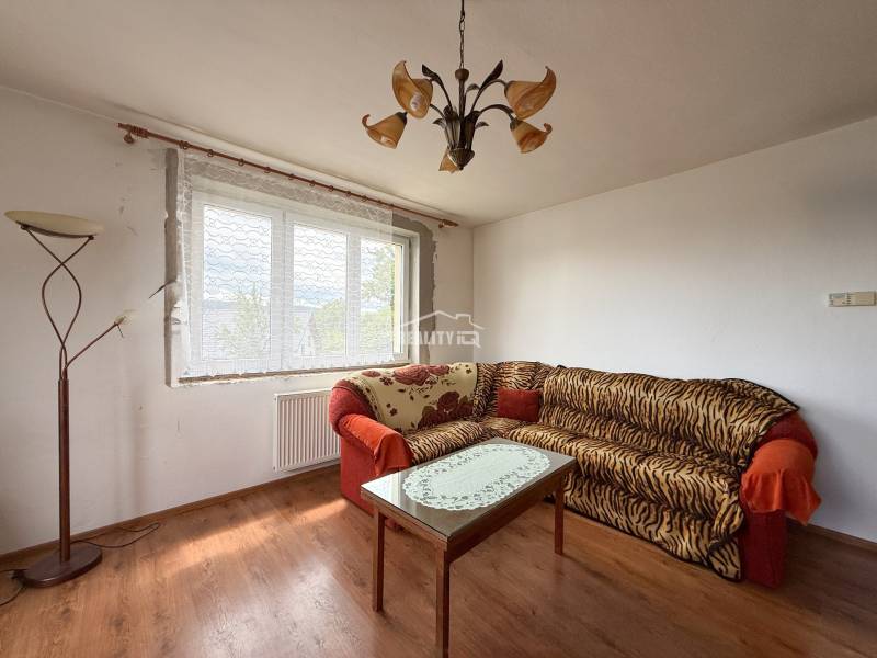 Living room with a sofa, table, and floor lamp in a family house.
