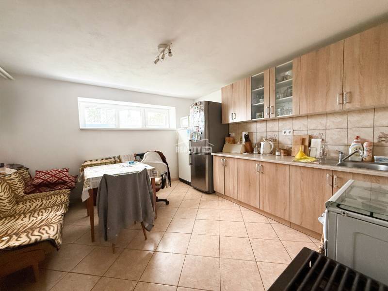A kitchen in a family house with a dining table and a kitchen unit.