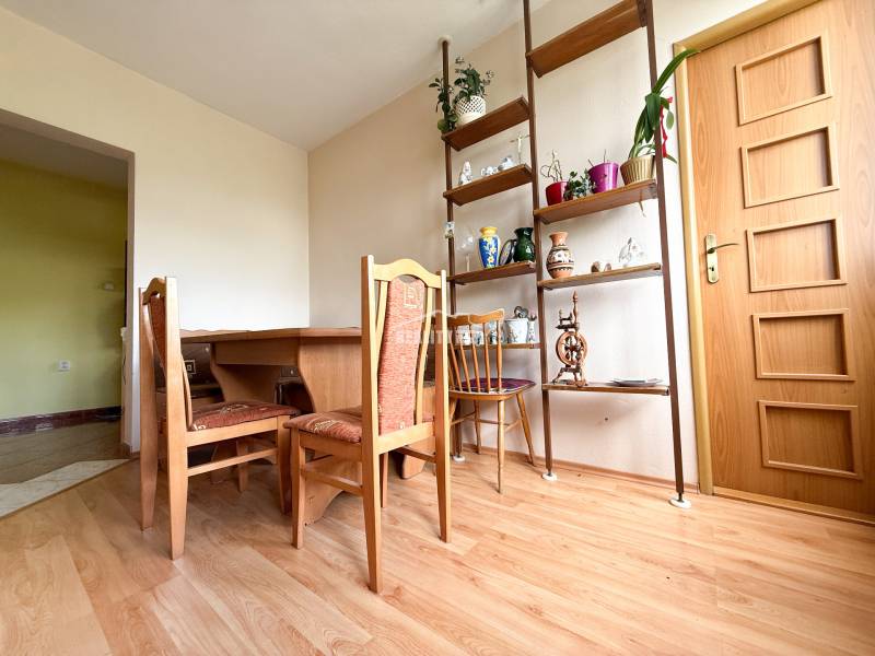 Dining room in a family house with a wooden table, chairs, and decorative shelves.