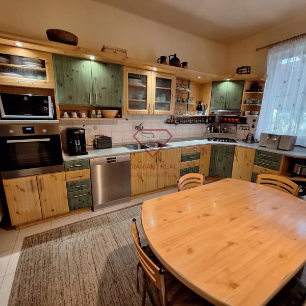 A kitchen in a family house with a wooden cabinet and a dining table.