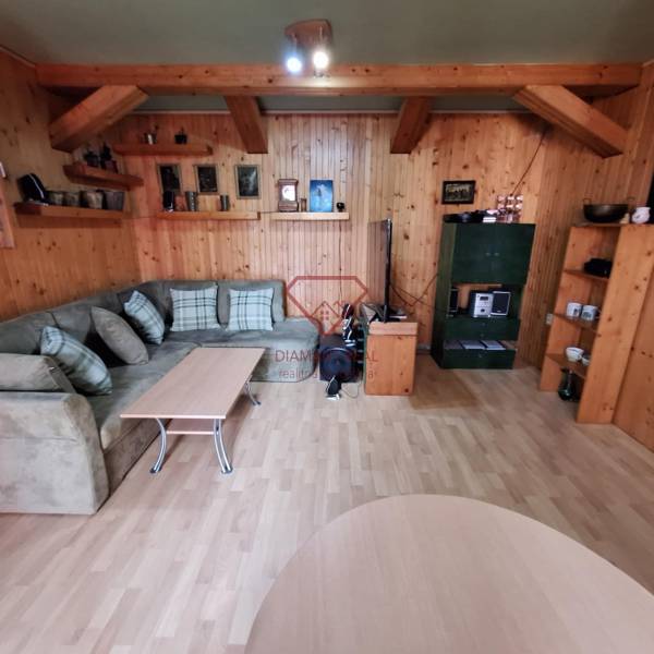 A cozy living room with wooden paneling, a couch, and a table in a family house.