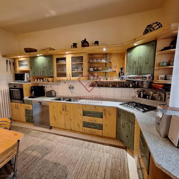 A kitchen in a family house with wooden cabinets and kitchen appliances.