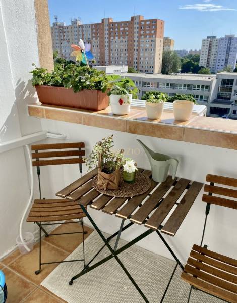 Balcony of a 3-room apartment with wooden furniture and a view of Petržalka.