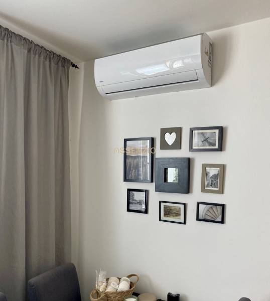 Air conditioning and framed photographs on the wall in a 3-room apartment.