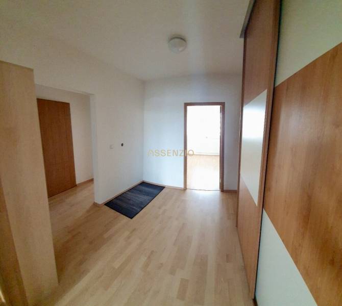 A hallway in a 3-room apartment with a wooden floor and a built-in wardrobe.