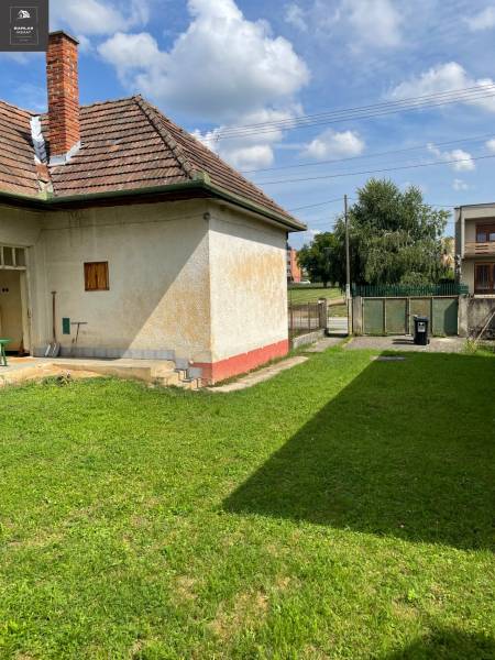 A family house in Trenčianske Stankovce with a grassy plot and a brick roof.