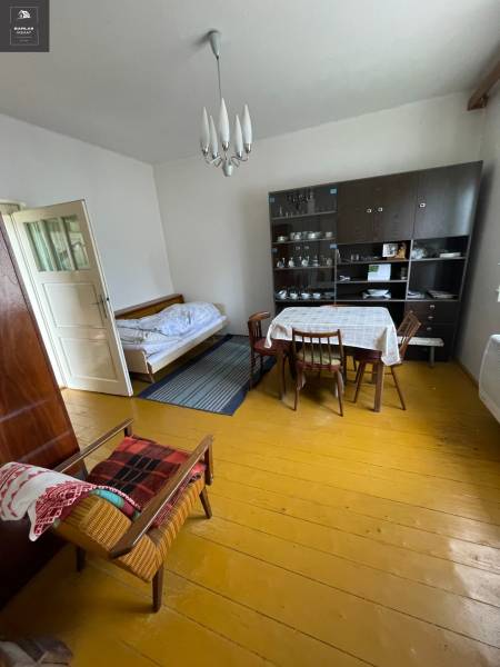 Interior of a family house with a dining table, bed, and showcase.