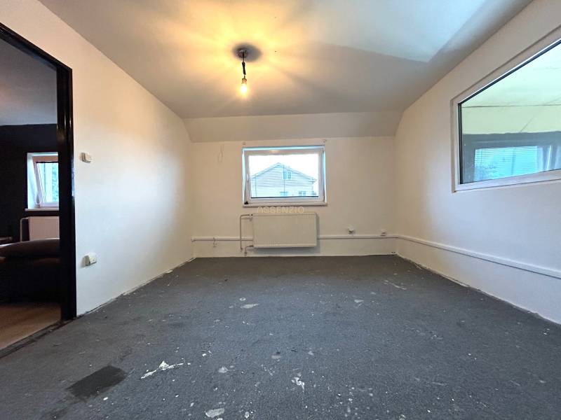 An empty room in a 4-room apartment with a window, light, and a heating unit.