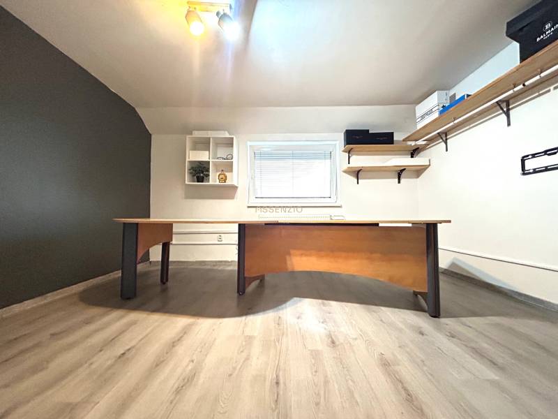 Office with a desk and shelves in a 4-room apartment, light flooring, minimalist design.
