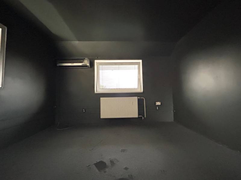A dark room in a 4-room apartment with air conditioning and a radiator under the window.