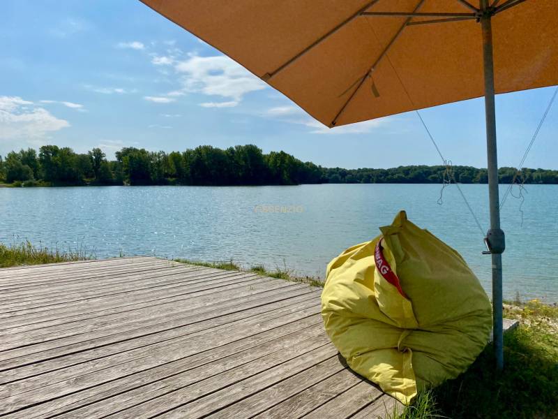 Wooden pier and bean bag under an umbrella by the lake in Vojka nad Dunajom.