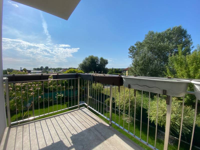 The balcony of a family house in Vojka nad Dunajom with a view of the green garden.