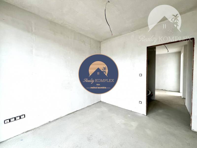Unfinished room in a family house with white walls and a concrete floor.