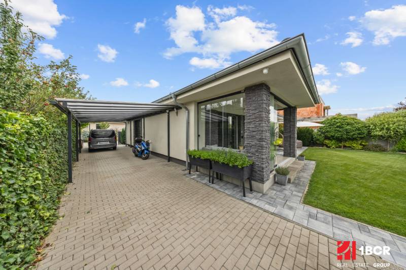 A family house on Feniklová Street in Malinovo with a garden and a carport.