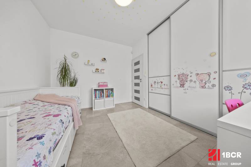 Children's room in a family house with a bed, bookshelf, and wardrobe with a children's motif.