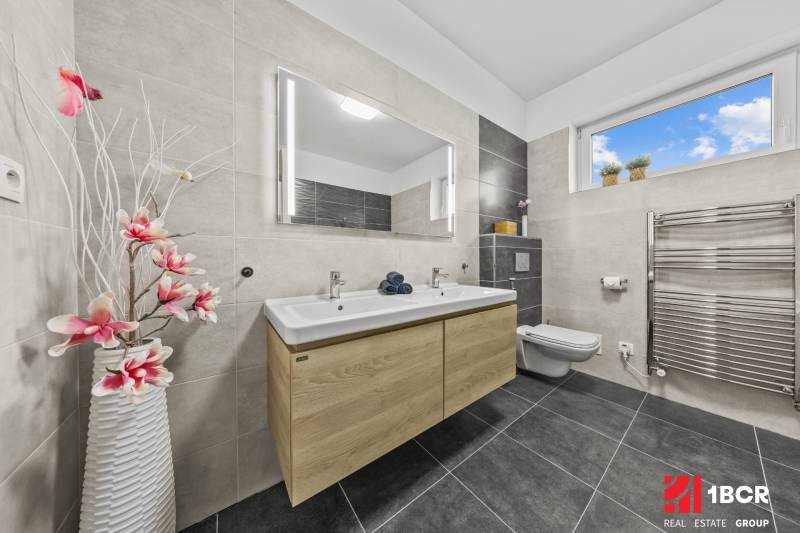 A bathroom with a double sink and floral decoration in a family house.