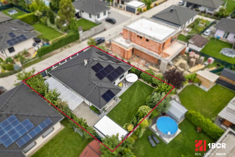 A family house on Feniklová Street in Malinovo, with photovoltaic panels and a garden.
