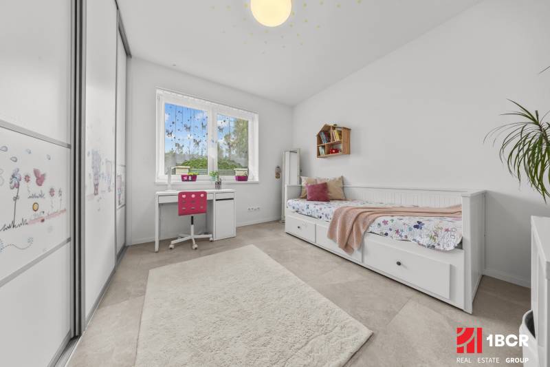 A children's room in a family house with a desk, bed, and wardrobe.