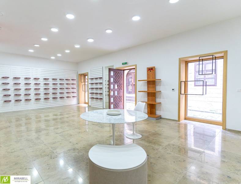 Spacious offices with wooden shelves and a round table, bright tiles.