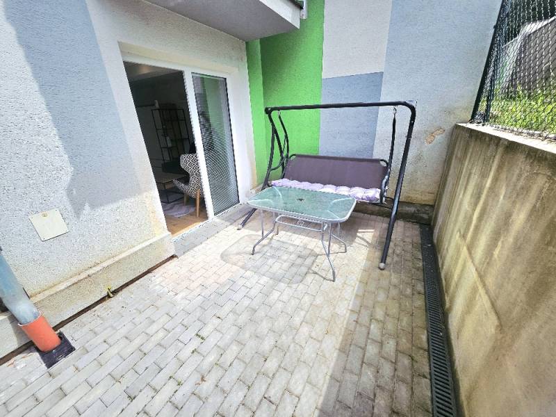 A terrace with a swing and a table in Bánovce nad Bebravou at a 1-room apartment.