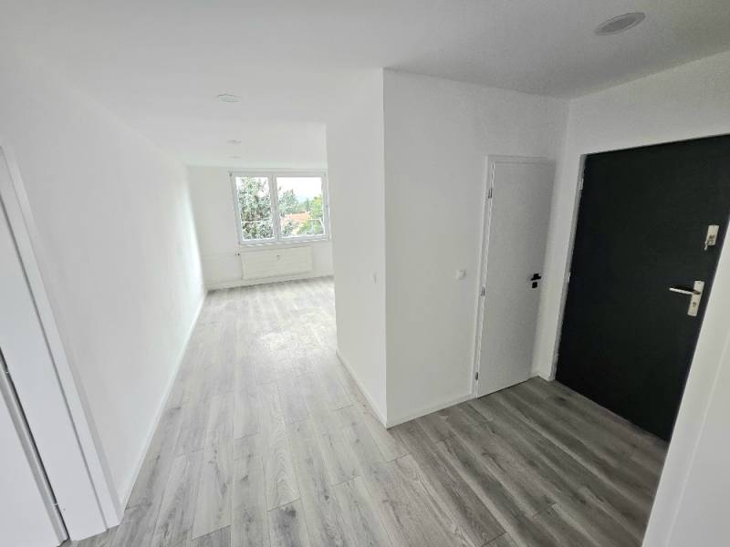A bright hallway and floor in a 3-room apartment with a large window.