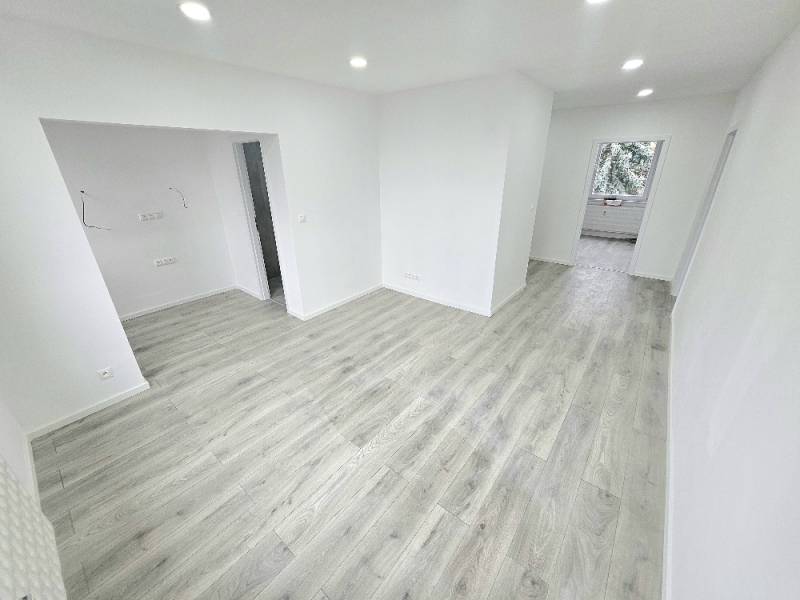 Light floor and white walls in a 3-room apartment with a spacious hallway.