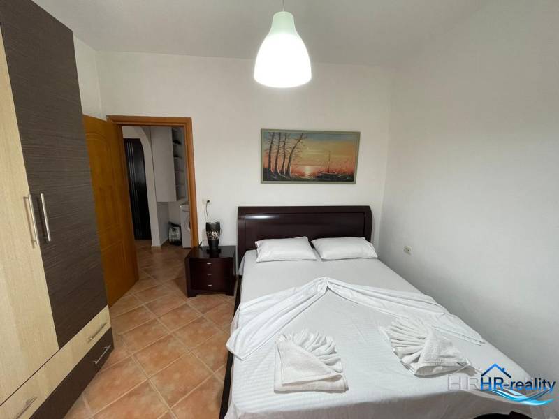 A bedroom in a holiday apartment with a double bed, wardrobes, and a decorative painting on the wall.