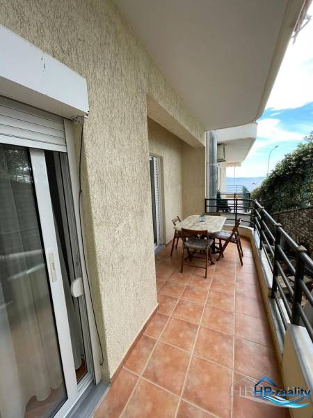 A balcony with seating in a holiday apartment in Sarandë, with a sea view.