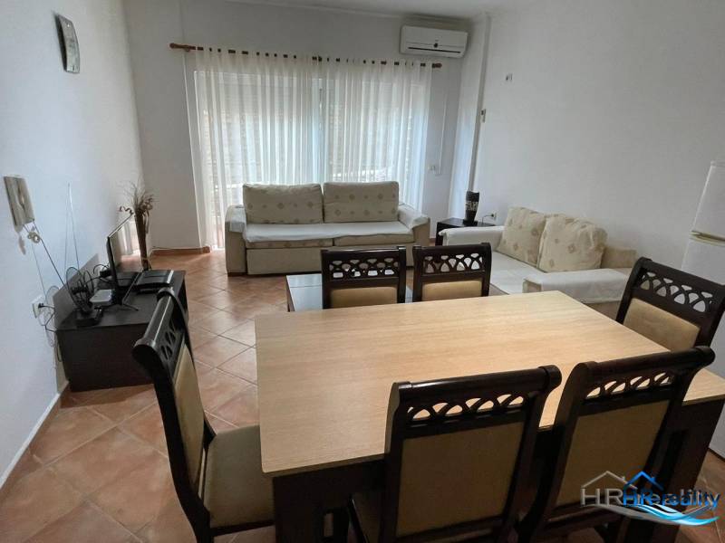 Living room with a dining table and a sofa in a holiday apartment.