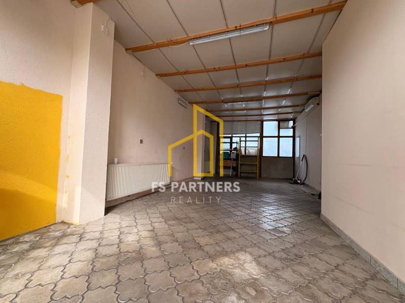 Interior of commercial premises with tiling and a window, suitable for rent.