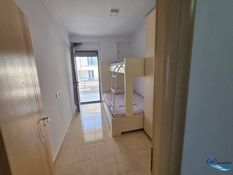 Children's room in a holiday apartment with access to a balcony and a bunk bed.