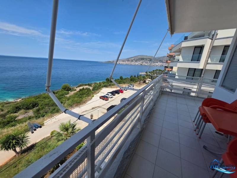 The balcony of a holiday apartment in Sarandë with a view of the blue sea and coastline.
