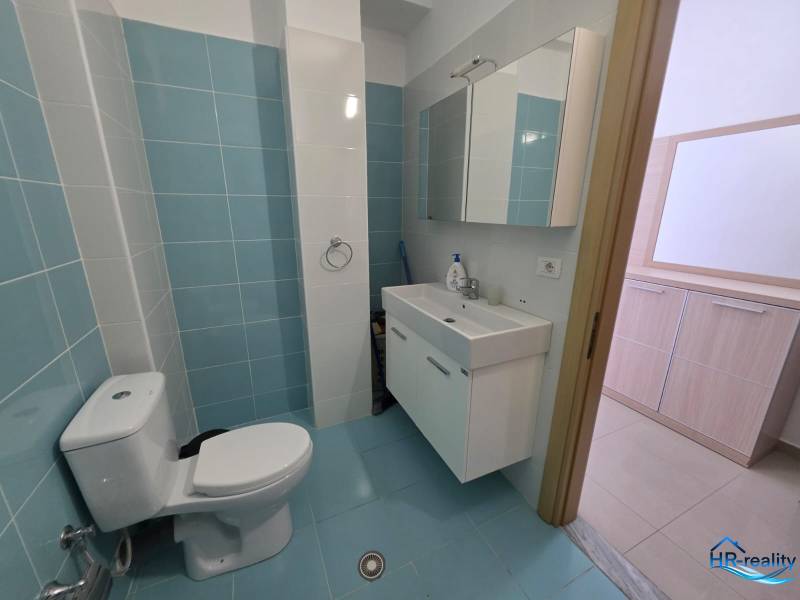 Bathroom with light blue tiles in a Holiday Apartment, sink and mirror cabinet.