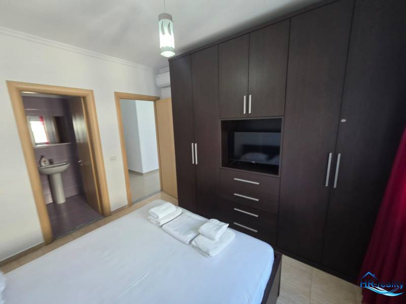 Bedroom in a holiday apartment with a large wardrobe and an en-suite bathroom.