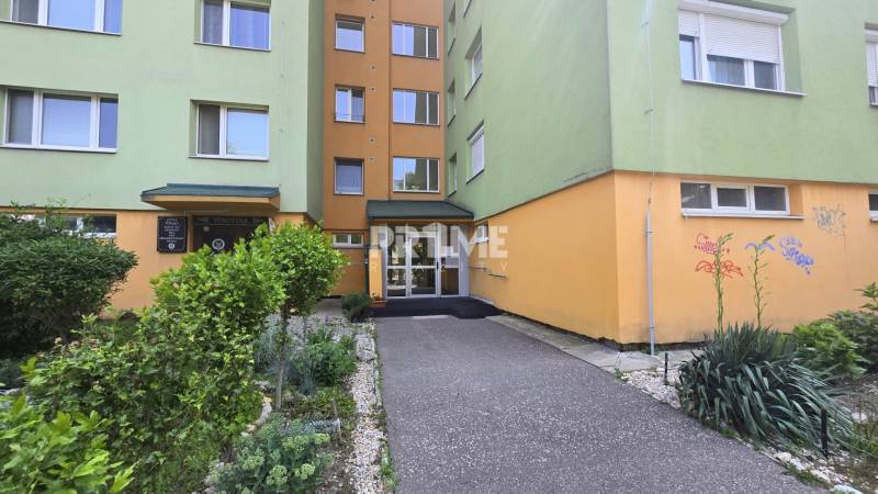 Entrance to the apartment building on Osuského Street in Bratislava - Petržalka with landscaped greenery.