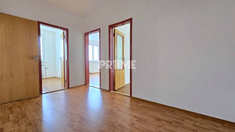 A corridor with light laminate and three open doors in a 3-room apartment.