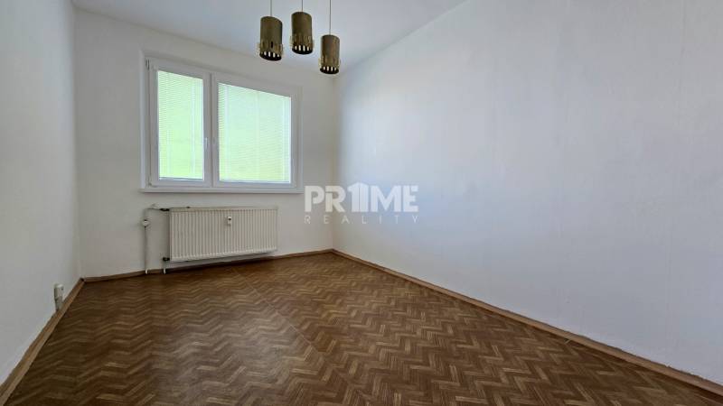 A room in a 3-room apartment with wooden flooring, white walls, and a window with blinds.